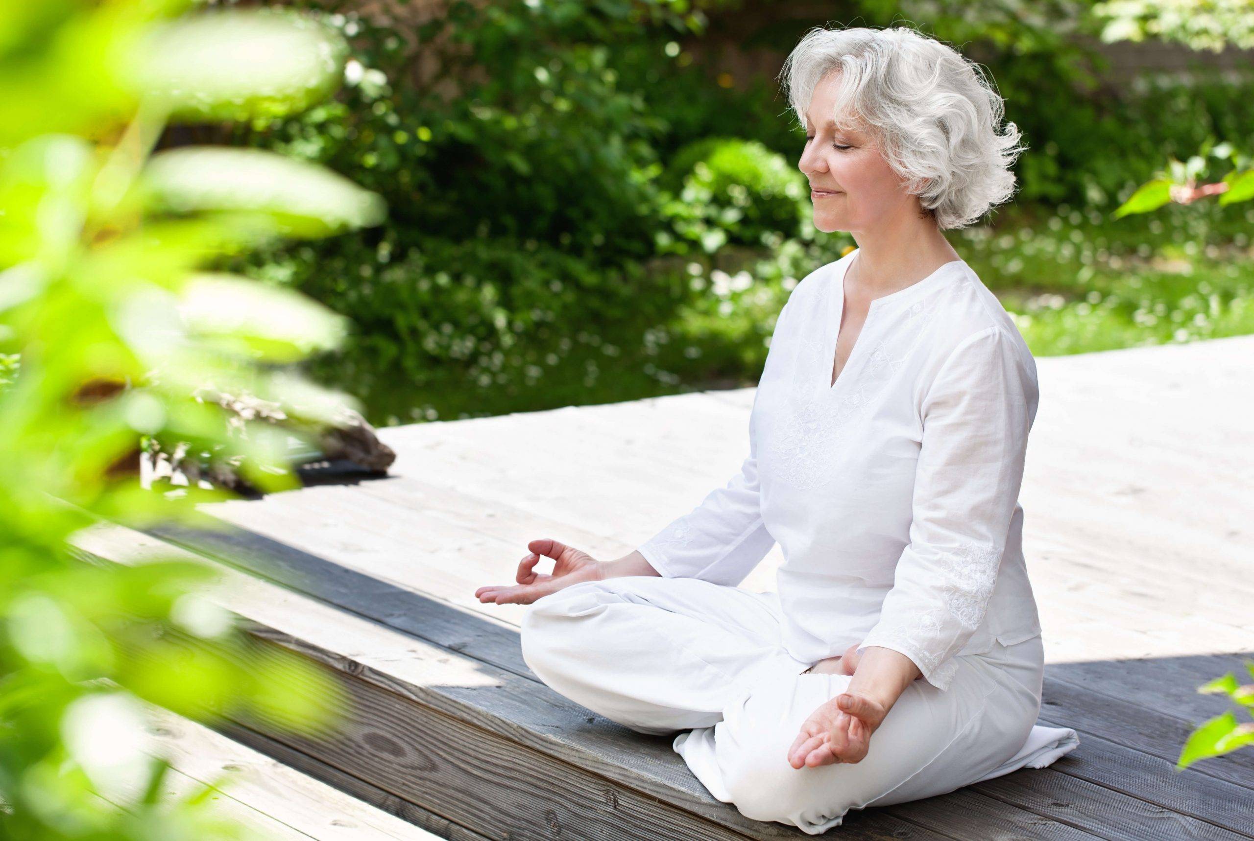lady meditating on yoga mat outdoors